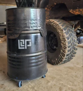 Black 55 Gallon garbage can next to Jeep tire with LOP logo